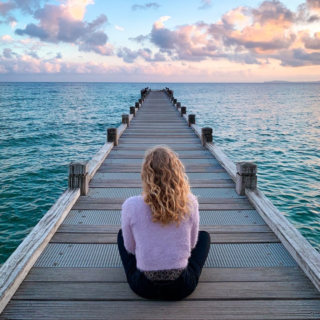 Stock woman back seated boardwalk 1